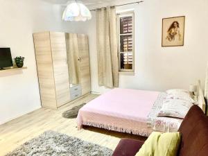 een witte slaapkamer met een bed en een raam bij Apartment by the sea SONJA in Dugi Rat