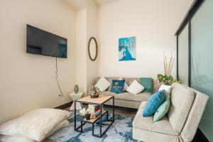 a living room with a couch and a tv at GLOBALSTAY New Downtown Hamilton Apartments in Hamilton