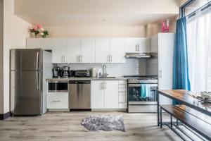 a kitchen with white cabinets and stainless steel appliances at GLOBALSTAY New Downtown Hamilton Apartments in Hamilton