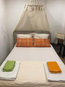 Una cama con tres almohadas encima. en La petite maison, en Portimão