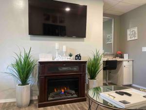 a living room with a fireplace and a tv on the wall at The Double U Escape in Roseburg