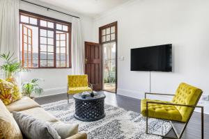 ein Wohnzimmer mit Couch und Fernseher in der Unterkunft Secure & Central: Villa with Views of Table Mountain in Kapstadt