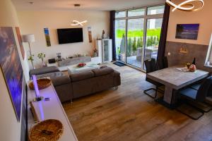 un soggiorno con divano e tavolo di Elegantes & modernes Apartment NeLi mit Terrasse, 100m zum Hafen Röbel Müritz a Röbel