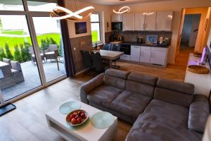 un soggiorno e una cucina con divano e tavolo di Elegantes & modernes Apartment NeLi mit Terrasse, 100m zum Hafen Röbel Müritz a Röbel