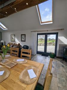 a living room with a wooden table and a couch at Treverrows Barn - Barn Conversion on the Farm in Penryn