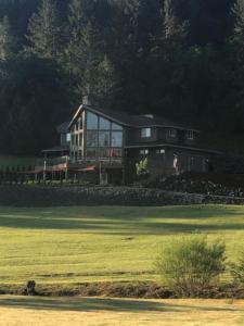 una casa grande sentada en la cima de un exuberante campo verde en The Double U Escape, en Roseburg