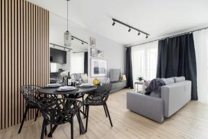 a dining room and living room with a table and a couch at Deluxe City Studio Kącik 10 by Renters in Krakow