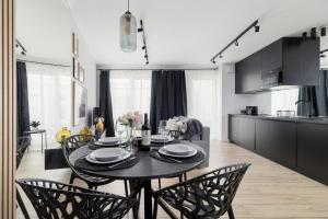 uma cozinha e sala de jantar com mesa e cadeiras em Deluxe City Studio Kącik 10 by Renters em Cracóvia