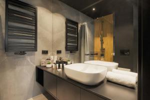uma casa de banho com um lavatório branco e uma banheira em Deluxe City Studio Kącik 10 by Renters em Cracóvia