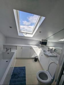 a bathroom with a toilet and a sink and a window at Treverrows Barn - Barn Conversion on the Farm in Penryn