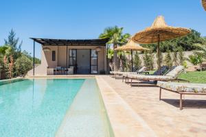 索维拉Villa Sunset - Maison entière的房子旁边有带椅子和遮阳伞的游泳池