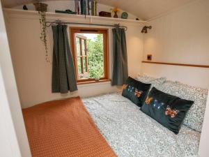 a bedroom with a bed and a window at Hurdlemakers Hut in Dorchester