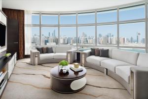 a living room with couches and a large window at Rosewood Abu Dhabi in Abu Dhabi