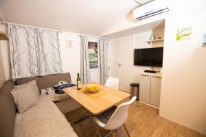 a small living room with a table and a couch at Mobile Homes 'JAKOV', Camp Soline in Biograd na Moru