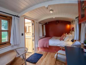 a small room with a bed in a train car at Spindleberry Hut in Dorchester
