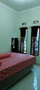 - une chambre avec un lit doté de draps rouges et de fenêtres dans l'établissement Kelana Homestay, 