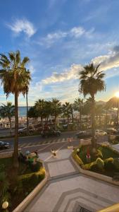 Blick auf einen Parkplatz mit Palmen in der Unterkunft Appartement Relais de la Reine Cannes Croisette in Cannes
