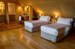 a hotel room with two beds and a bathroom at Correntoso Lake & River Hotel in Villa La Angostura