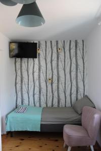 1 dormitorio con 1 cama y una pared con árboles en Leśny Mech, en Augustów