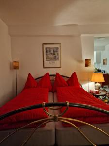 sypialnia z łóżkiem z czerwonymi poduszkami w obiekcie Bastis Luxury Studios - Free Parking w Lucernie