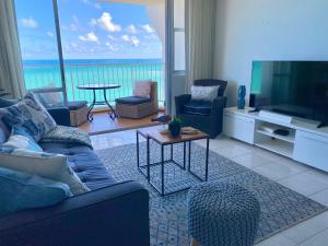 a living room with a couch and a flat screen tv at Marbella del Caribe Isla Verde Beachfront in San Juan