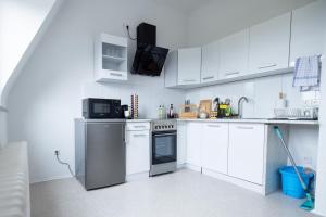 a kitchen with white cabinets and a stove top oven at SUPERIOR! Nespresso - Küche - Prime - Parkplatz in Duisburg