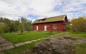 a large red house with a yard with a yard at STF Tivedstorp in Tivedstorp