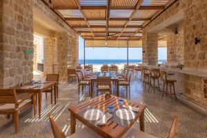 a restaurant with tables and chairs and a view of the ocean at Wadi Sabarah Lodge in Marsa Alam City