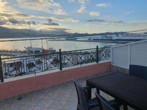a balcony with a table and chairs overlooking a marina at Johanna Sea View Apartment in Lixouri