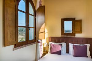a bedroom with a bed and two windows at Boccioleto Resort in Montaione