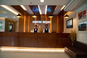 two men standing at the reception counter of a morgan room at Modern Resort in Cox's Bazar