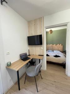 a bedroom with a desk with a laptop and a bed at Studio - 19 in Rochefort-en-Terre
