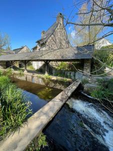 un pont sur une rivière avec une maison en arrière-plan dans l'établissement Studio - 19, à Rochefort-en-Terre