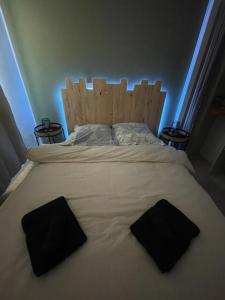 a large bed with two black pillows on it at Studio - 19 in Rochefort-en-Terre