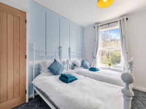 2 camas en una habitación con ventana en Primrose Cottage, en Teignmouth