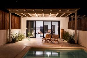 a patio with a pool and a table and chairs at Mea Terra Villas in Lachania