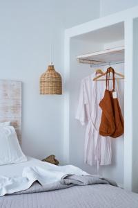 Un dormitorio con paredes blancas y una cama y un bolso colgante. en Mea Terra Villas, en Lachania 17 fotos más