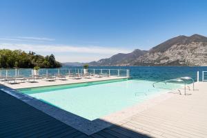 a swimming pool with a view of the water and mountains at Araba Fenice Hotel in Iseo
