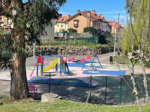 um parque com parque infantil com escorrega em Piscina comunitaria y parking en Mogro em Mogro