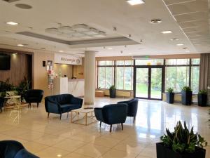 a lobby with chairs and tables in a building at Hotel Ostaniec in Kroczyce +104 photos