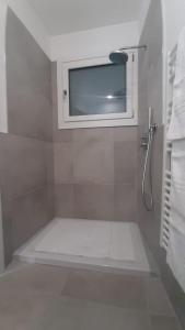 y baño con bañera, ventana y toallas. en Top Lake View, en Faggeto Lario 