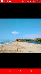 a woman on a beach playing with a frisbee at PALOMINO- HOSTEL BALNEARIO RIO ANCHO in Palomino