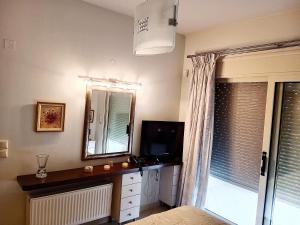 a room with a television and a mirror and a window at Korfe Estate in Fodele