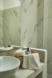 Un baño blanco con lavabo y espejo. en Mea Terra Villas, en Lachania