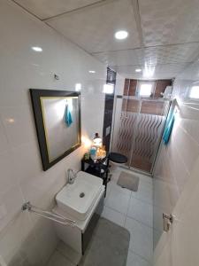 een witte badkamer met een wastafel en een douche bij ANTALYA DubleX in Antalya