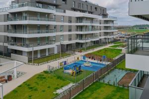 an apartment building with a pool and a playground at Apartment with 2 Bedrooms & Parking Wrocław by Renters in Wrocław