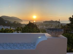a bowl on a ledge with a sunset in the background at Villa la Milanina in Lipari