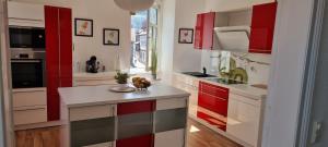 a kitchen with red and white cabinets and a counter at Ferienwohnung Marktblick Goslar in Goslar