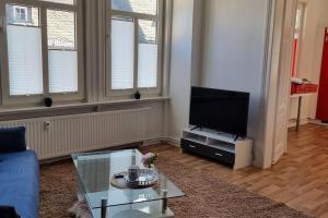 a living room with a blue couch and a tv at Ferienwohnung Marktblick Goslar in Goslar