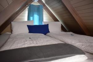 a bed with a blue curtain in a attic at Chalet im See- Nr 44 in Rust